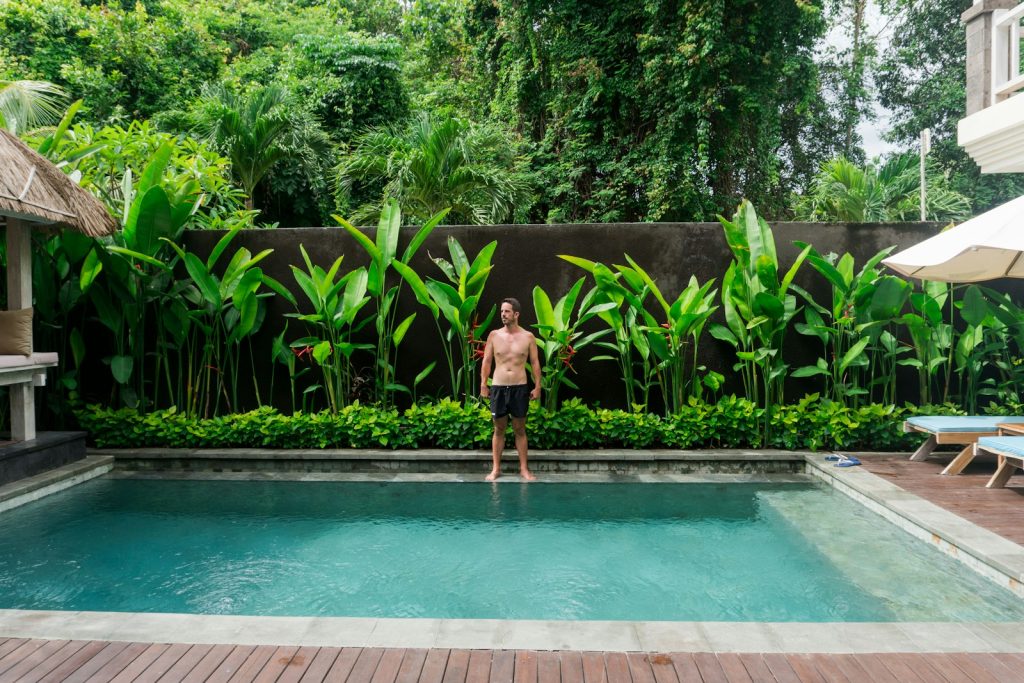 A man standing next to a swimming pool